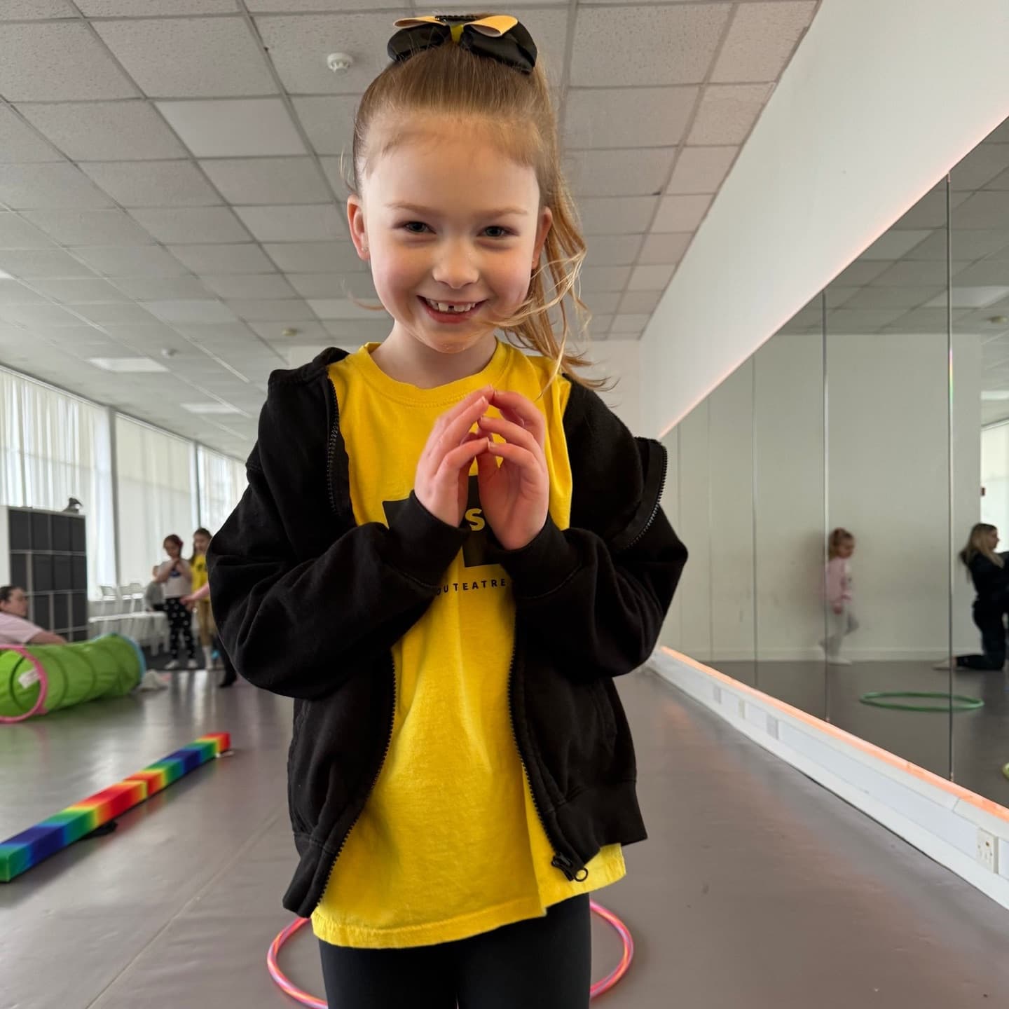 Young performer smiling in a yellow Stand-Out Theatre School t-shirt
