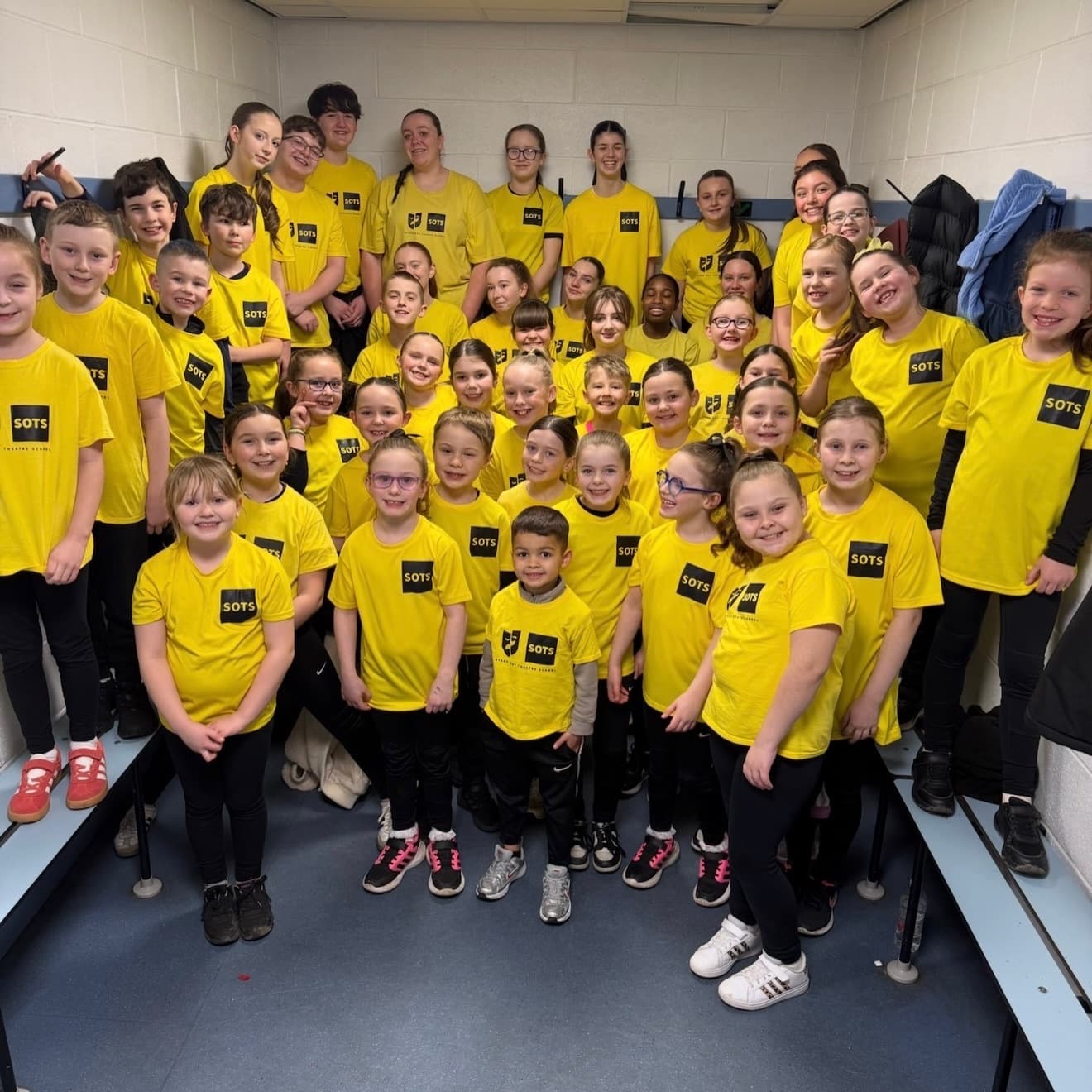 Backstage group photo of students in Stand-Out yellow t-shirts